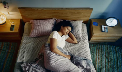 Indian adult sleeping on their side with head elevated in a calm, clutter-free bedroom